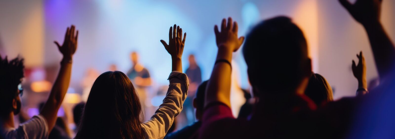 Hands In The Air, People Who Are Praising God And Jesus At A Church Service With Worship Band In The Background,